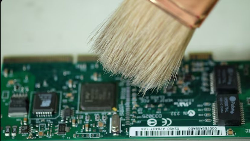 Brush cleaning a circuit board